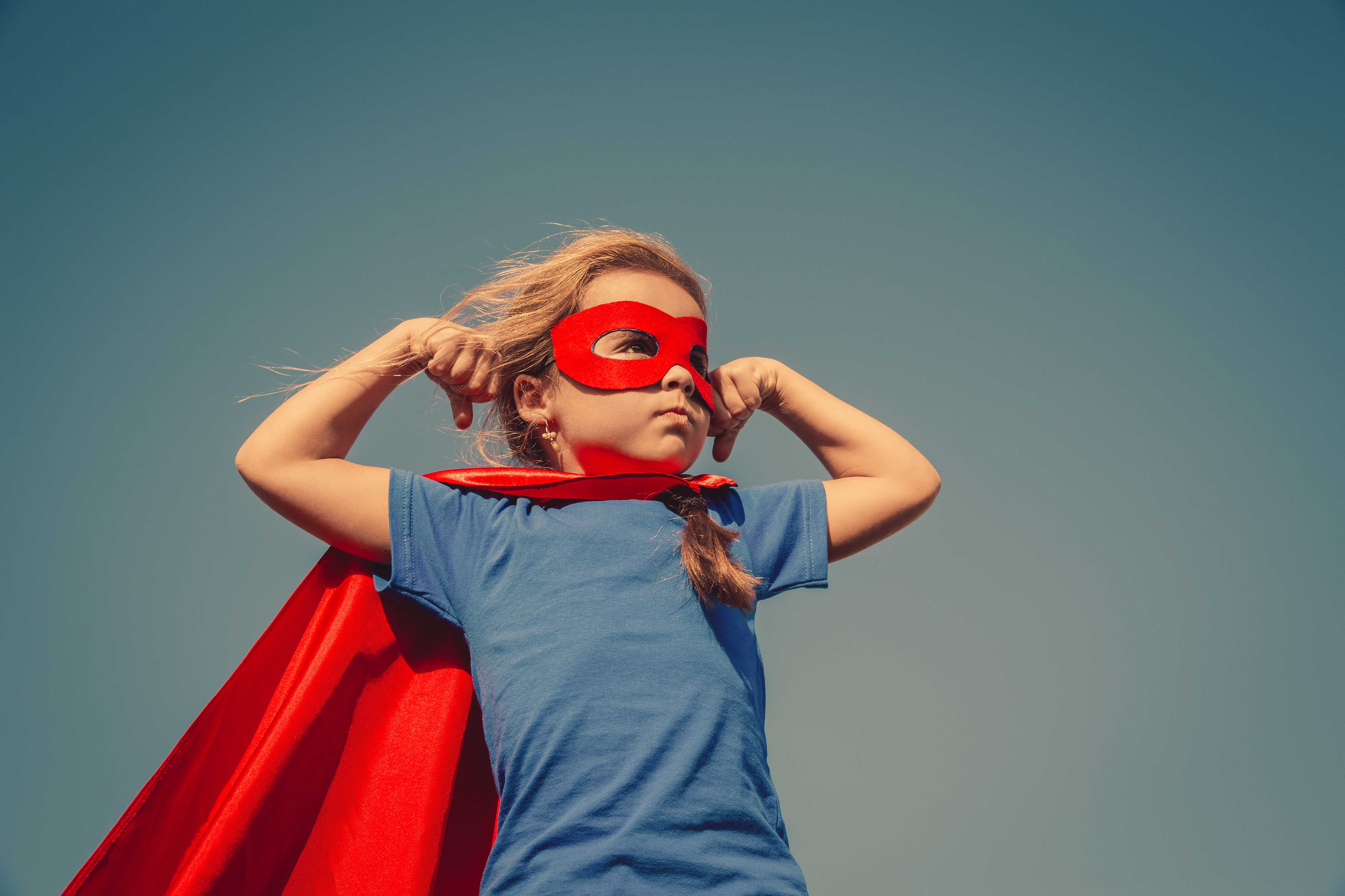 A young girl wearing a super hero outfit