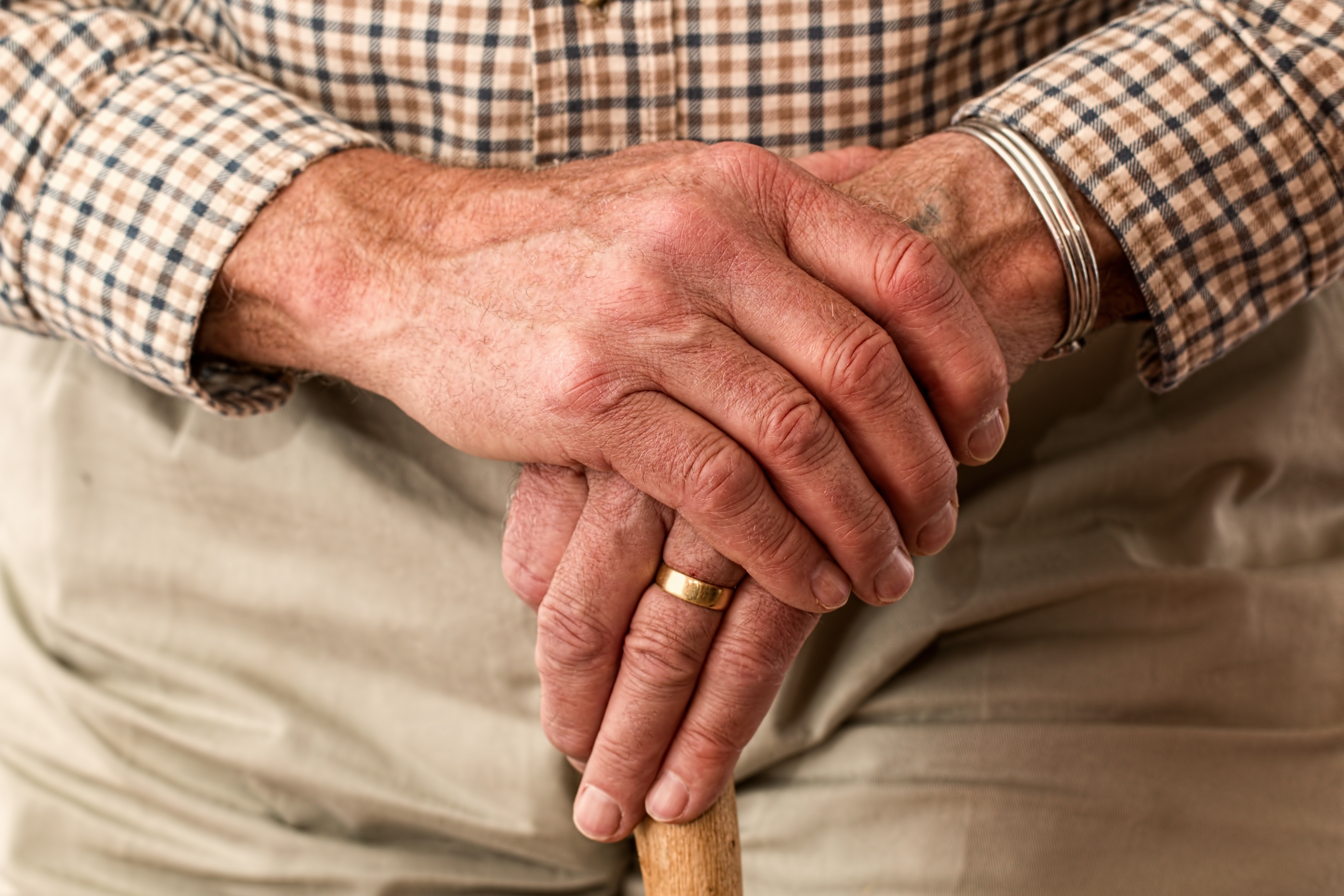An older man resting on a walking stick