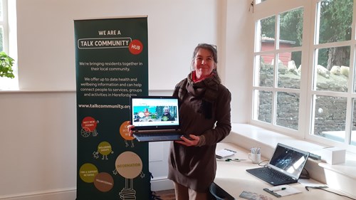 A hub volunteer holding a laptop
