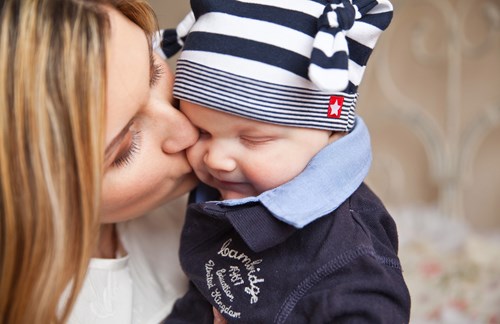 A photo of a mother kissing her baby