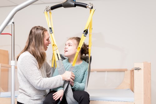 A teenage girl using a mobility hoist