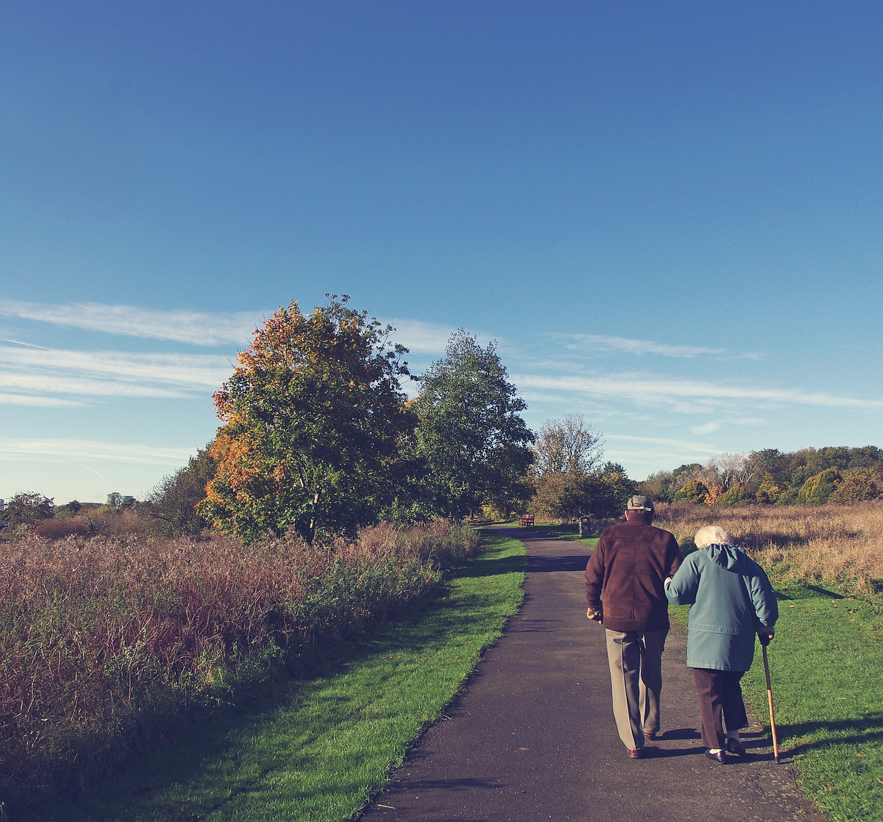 An older couple walking arm in arm together