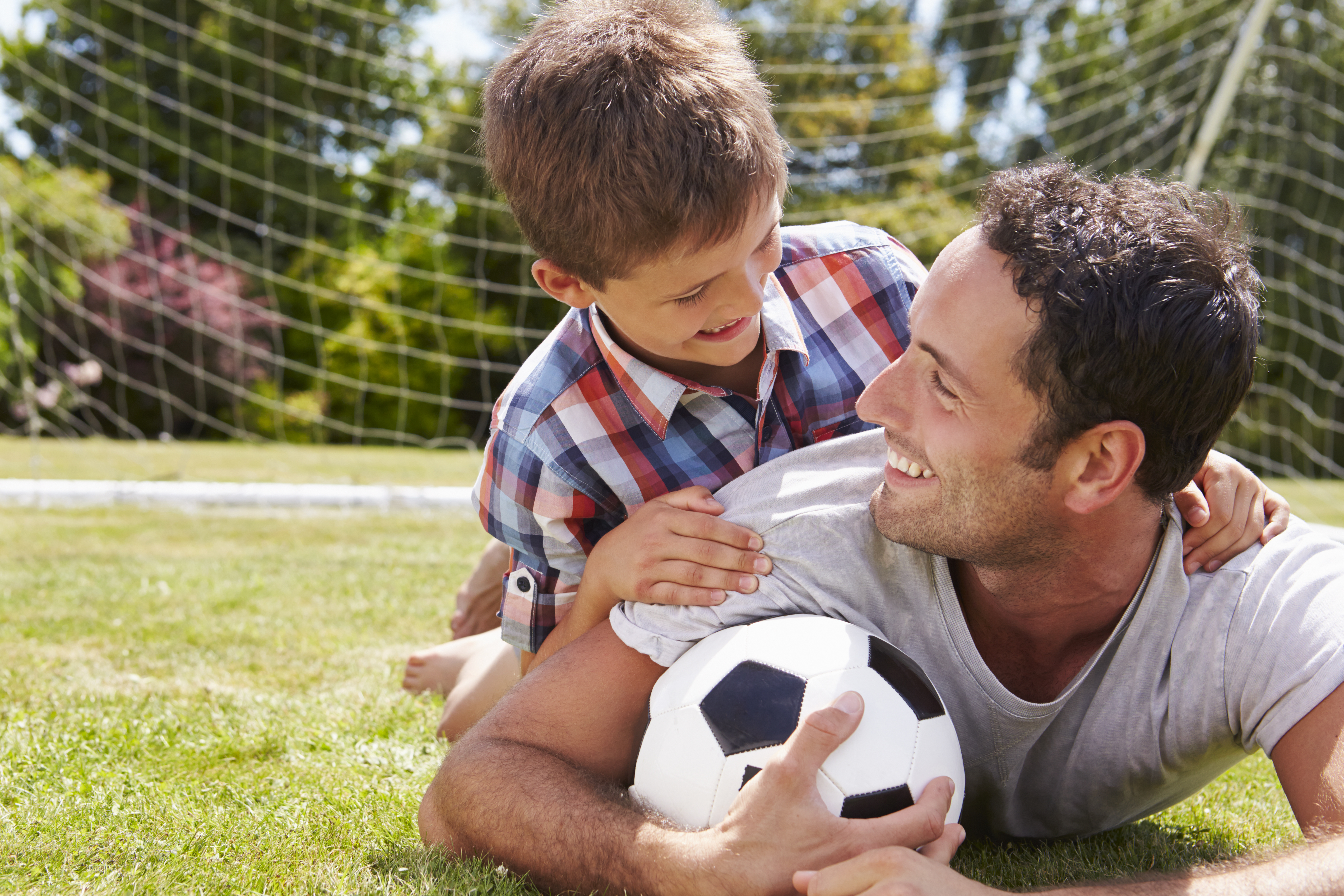 Man and young boy playing football